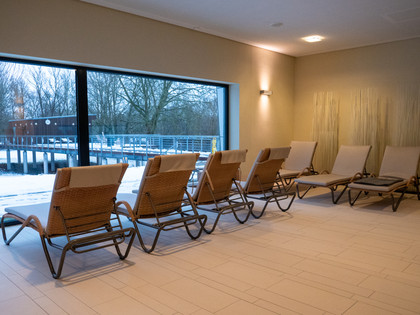 Sauna Ruhebereich Ruheliegen vor einer großen Fensterfront