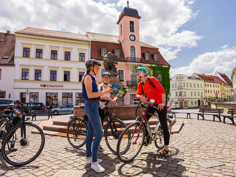Radfahrerinnen am Ringelnatzbrunnen auf dem Marktplatz Wurzen