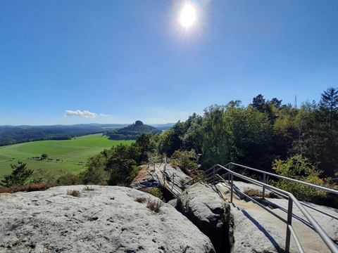 Kaiserkrone_Blick auf den Zirkelstein_Sommer_2500px.jpg Blick über Felsen hinweg auf grünes Tal und Zirkelstein im Sonnenlicht, eingefasst von Wäldern.