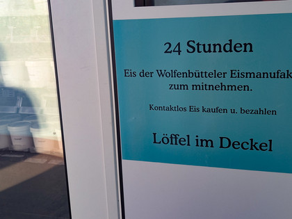 Eisautomat (2) Schild am Eisautomat: 24 Stunden Eis der Wolfenbütteler Eismanufaktur zum mitnehmen. Kontaktlos Eis kaufen und bezahlen, Löffel im Deckel.