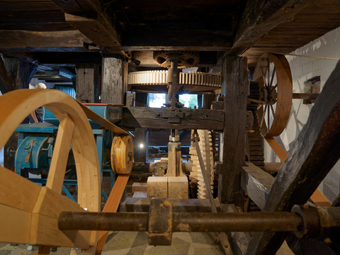 Dümmlinghauser Mühle Historische Wassermühle mit komplexen Holzzahnrädern und Mechanismen in einem rustikalen Innenraum.