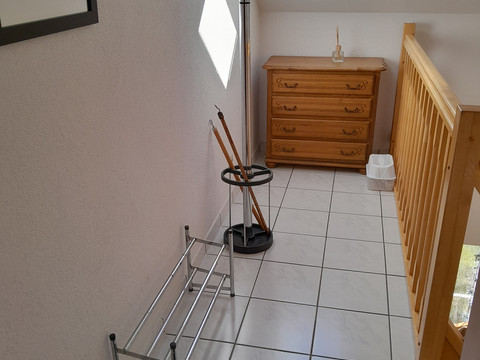 Ferienwohnung Preyersmühle Flur im Obergeschoss mit Garderobe, Kommode und Dachfenster, helles Licht flutet den Raum.