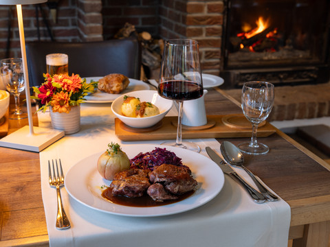 Eimermacher 02.jpg Gemütliches Abendessen am knisternden Kamin: Ente mit Rotkraut und Kloß, Wein und herbstlicher Deko.