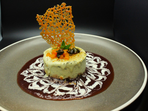 Eimermacher 08.JPG Ein kunstvoll angerichtetes Dessert mit Schokoladensauce und dekorativem Karamellkreisel auf Teller.