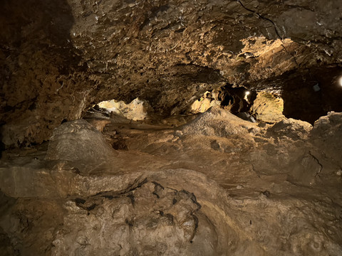 Ansicht Tropfsteinhöhle Natürliche Kalksteinhöhle mit unregelmäßig geformten Wänden und warmem Licht, das Texturen hervorhebt.