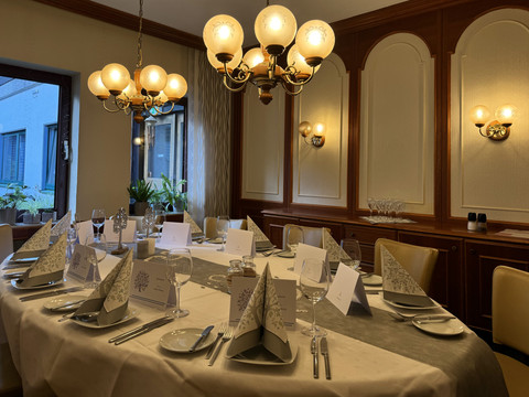 Innenansicht Waldhotel Tropfsteinhöhle Eleganter runder Tisch in stilvollem Restaurant, gedeckt für ein festliches Abendessen, mit Kerzenschein.