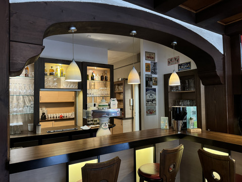 Ansicht Bar - Waldhotel Tropfsteinhöhle Gemütliche Bar mit Holztresen, dekorativen Leuchten und gut gefüllten Regalen im Hintergrund.