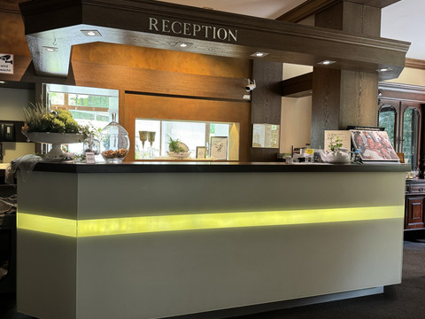 Rezeption - Waldhotel Tropfsteinhöhle  Empfangstresen in einem Hotel, modern beleuchtet, mit Dekorationen und einem freundlichen Ambiente.