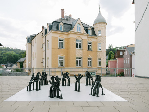 PurplePath_42 Tage_Bettina Pousttchi in Schwarzenberg_Kunstwerk_Foto_Johannes Richter.jpg.jpg Schwarze Skulpturen von Bettina Pousttchi vor einem gelben Haus in urbaner Umgebung.Black sculptures by Bettina Pousttchi in front of a yellow house in an urban environment.Černé sochy Bettiny Pousttchi před žlutým domem v městském prostředí.Czarne rzeźby Bettiny Pousttchi przed żółtym domem w środowisku miejskim.Zwarte sculpturen van Bettina Pousttchi voor een geel huis in een stedelijke omgeving.Sculture nere di Bettina Pousttchi davanti a una casa gialla in un ambiente urbano.
