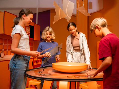 EscapeRoom Vier Kinder experimentieren gemeinsam an einem Tisch in einem kreativen Raum.Four children experiment together at a table in a creative space.Čtyři děti společně experimentují u stolu v kreativním prostoru.Czworo dzieci eksperymentuje razem przy stole w kreatywnej przestrzeni.Vier kinderen experimenteren samen aan een tafel in een creatieve ruimte.Quattro bambini sperimentano insieme a un tavolo in uno spazio creativo.