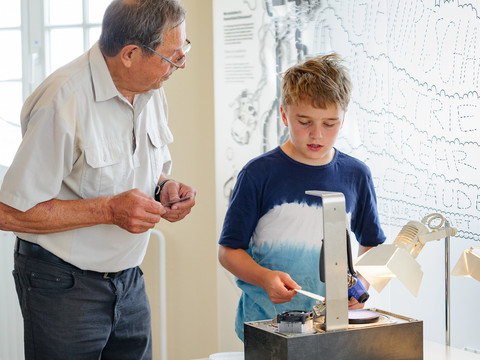 Technische Sammlungen der Stadt Dresden Ein älterer Mann und ein Junge erkunden interaktiv eine Ausstellung mit technischen Geräten.An older man and a boy interactively explore an exhibition with technical devices.Starší muž a chlapec interaktivně zkoumají výstavu s technickými zařízeními.Starszy mężczyzna i chłopiec interaktywnie eksplorują wystawę za pomocą urządzeń technicznych.Een oudere man en een jongen verkennen interactief een tentoonstelling met technische apparaten.Un uomo anziano e un ragazzo esplorano in modo interattivo una mostra con dispositivi tecnici.