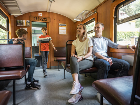 Junge Familie fährt mit der Lößnitzgrundbahn in Dresden Elbland