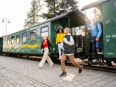 Junge Familie steigt aus der Lößnitzgrundbahn in Dresden Elbland aus
