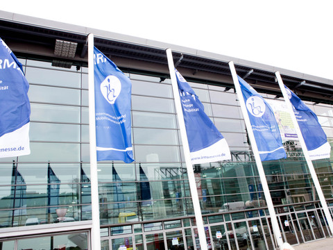 Halle-und-Flaggen-©-Escales-Verlag.jpg Flaggen wehen vor der Messehalle.