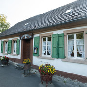 Stindermühle in Erkrath.jpg Altes, charmantes Fachwerkhaus mit grünen Fensterläden und bunten Blumen vor der Eingangstür.