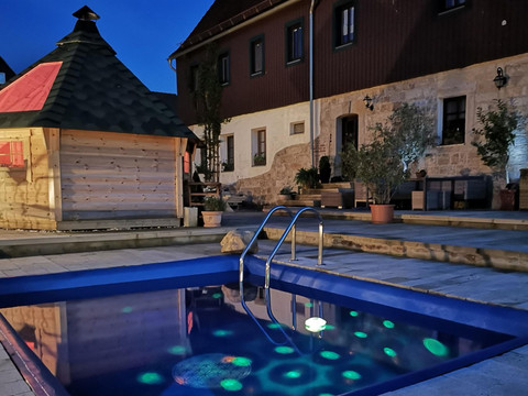 Außenbereich mit Pool am Abend