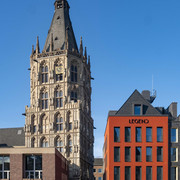 Altermarkt Der historische Rathausturm am Alter Markt in Köln erhebt sich majestätisch neben einem modernen roten Gebäudekomplex.The historic town hall tower on Cologne's Alter Markt rises majestically next to a modern red building complex.