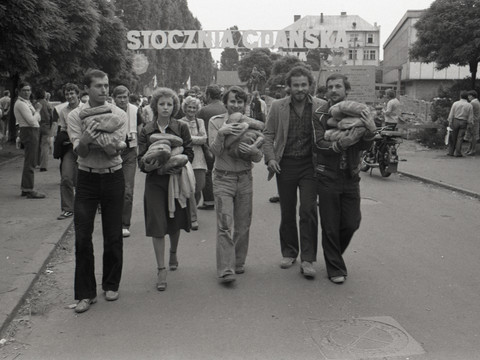 Freiheit_Streik_Bogusław Nieznalski_Sammlung Europäisches Solidarność-Zentrum.jpg Menschen mit Kindern marschieren vor dem Tor der Danziger Werft während des Streiks.People with children march in front of the gate of the Gdansk shipyard during the strike.Lidé s dětmi pochodují před branou gdaňské loděnice během stávky.Ludzie z dziećmi maszerują przed bramą Stoczni Gdańskiej podczas strajku.Mensen met kinderen marcheren voor de poort van de scheepswerf in Gdansk tijdens de staking.Persone con bambini marciano davanti al cancello del cantiere navale di Danzica durante lo sciopero.