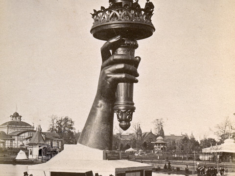 Freiheit_La_Liberte_C. Kempf.jpg Große Fackel der Freiheitsstatue im Bau, umgeben von Menschen und Zelten, in einer Ausstellung.Large torch of the Statue of Liberty under construction, surrounded by people and tents, in an exhibition.Velká pochodeň Sochy svobody ve výstavě, obklopená lidmi a stany.Duża pochodnia Statuy Wolności w budowie, otoczona ludźmi i namiotami, na wystawie.Grote fakkel van het Vrijheidsbeeld in aanbouw, omringd door mensen en tenten, in een tentoonstelling.Grande fiaccola della Statua della Libertà in costruzione, circondata da persone e tende, in una mostra.