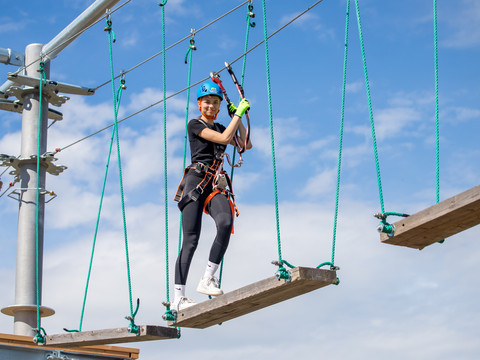 Kletterpark Markkleeberg - Freizeitaktivitäten in Leipzig und Region.jpg Das Foto zeigt eine Frau beim Klettern auf einem Kletterelement im Kletterpark Markkleeberg.
