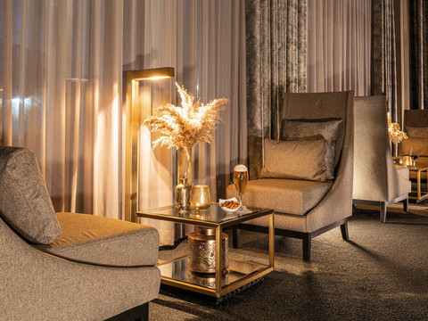 Victor's Residenz-Hotel Gummersbach Gemütliche Lounge mit bequemen Sesseln, elegant dekoriertem Tisch und stimmungsvoller Beleuchtung.