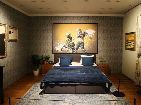 Banksy-Kunstwerke in einem stilvollen Schlafzimmer mit großem Gemälde und geschmackvoller Dekoration.Banksy artwork in a stylish bedroom with a large painting and tasteful decoration.Umělecké dílo Banksy ve stylové ložnici s velkým obrazem a vkusnou výzdobou.Dzieło Banksy'ego w stylowej sypialni z dużym obrazem i gustowną dekoracją.Banksy kunstwerk in een stijlvolle slaapkamer met een groot schilderij en smaakvolle decoratie.Un'opera d'arte di Banksy in una camera da letto elegante con un grande quadro e decorazioni di gusto.
