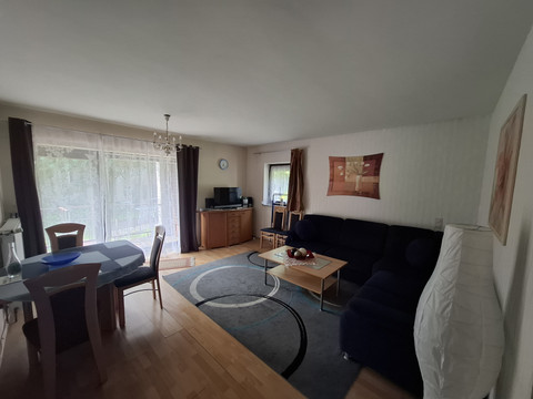 Wohn- u. Esszimmer FeWo 1 Helles Wohnzimmer mit Esstisch, Sofa und TV. Große Fenster mit Blick ins Grüne sorgen für Licht.