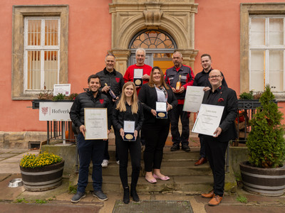 Klosterbrennerei Wöltingerode - Team mit Auszeichnung Das Team der Klosterbrennerei Wöltingerode präsentiert stolz die DLG-Auszeichnung auf der Treppe vor dem Klosterladen.
