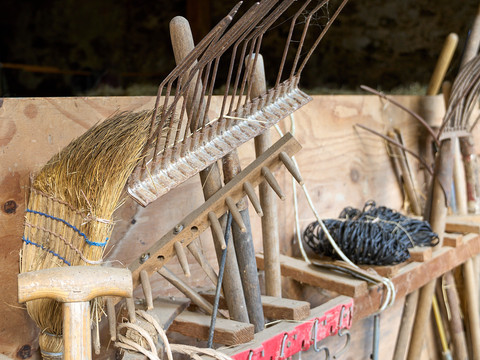 Gartengerätschaften aus Holz wie Harke, Besen und so weiter