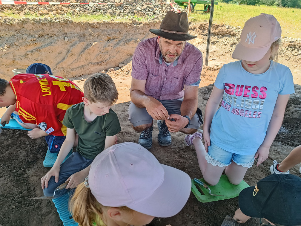 Archäologiepark_Grabung_Ralf_Kinder_WDR.jpg Ralf Mahytka mit Kindern bei der Grabung