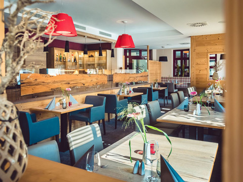 Restaurant Seinerzeit im Parkhotel Neustadt Ein modernes Restaurant mit hölzernem Interieur, eleganten Dekorationen und einladendem Lichtdesign.