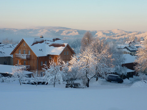 Ferienhaus Winterbergblick Ferienhaus in verschneiter Winterlandschaft an einem klaren Tag, umgeben von schneebedeckten Bäumen.Vacation home in a snowy winter landscape on a clear day, surrounded by snow-covered trees.Rekreační dům v zasněžené zimní krajině za jasného dne, obklopený zasněženými stromy.Dom wakacyjny w śnieżnym zimowym krajobrazie w pogodny dzień, otoczony ośnieżonymi drzewami.Vakantiehuis in een besneeuwd winterlandschap op een heldere dag, omringd door besneeuwde bomen.Casa vacanze in un paesaggio invernale innevato in una giornata limpida, circondata da alberi innevati.