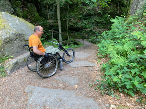 rotsachtige grond Ein Rollstuhlfahrer steht auf einem felsigen Wanderweg. A wheelchair user stands on a rocky hiking trail.Vozíčkář stojí na kamenité turistické stezce.Een rolstoelgebruiker staat op een rotsachtig wandelpad.
