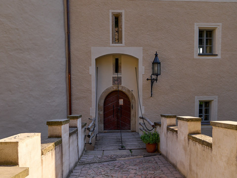Schloss Kuckuckstein Eingangsbereich Eingangsbereich des Schlosses mit Holztür, Treppen und einer Laterne.