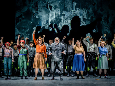 PR05_Rummelplatz__C__Nasser_Hashemi.jpg Eine Theatergruppe auf der Bühne hebt Arme im Jubel. Tänzer in farbenfrohen Outfits.