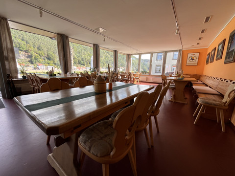 Einladender Gastraum des Restaurants "Zum Echtner" mit Holztischen, Sesseln und großem Fensterblick.
