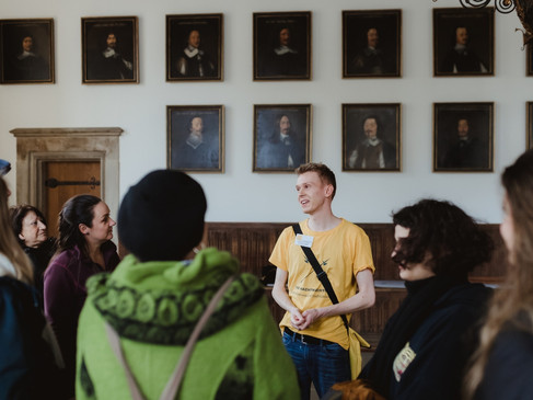 Rathaus- und Altstadt (2).jpg Eine Gruppe von Menschen steht in einem historischen Raum mit einem Guide, umgeben von Porträtgemälden.A group of people stand in a historical room with a guide, surrounded by portrait paintings.Een groep mensen staat in een historische kamer met een gids, omringd door portretschilderijen.En gruppe mennesker står i et historisk rum med en guide, omgivet af portrætmalerier.