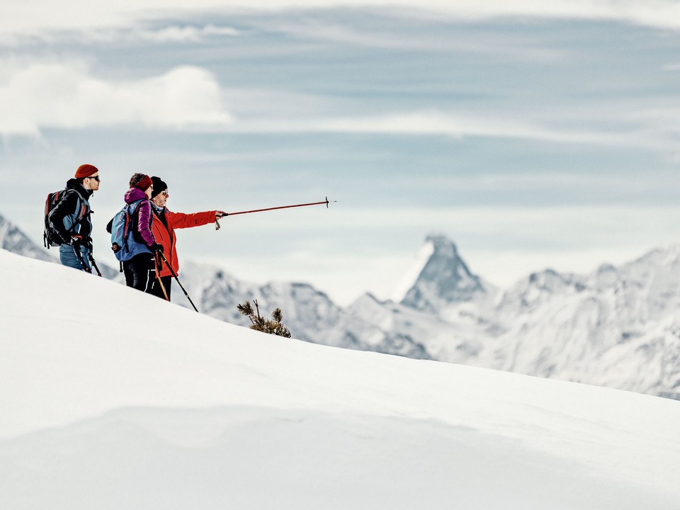 Guided ridge tour with panoramic break Teilnehmer einer Schneeschuhtour Aletsch Grattour verweilen mit Blick zum Matterhorn und diskutieren die Route am WintergratParticipants on a snowshoe tour Aletsch ridge tour linger with a view of the Matterhorn and discuss the route on the winter ridgeLes participants à une randonnée en raquettes sur l'arête d'Aletsch s'attardent avec vue sur le Cervin et discutent de l'itinéraire sur l'arête hivernale.