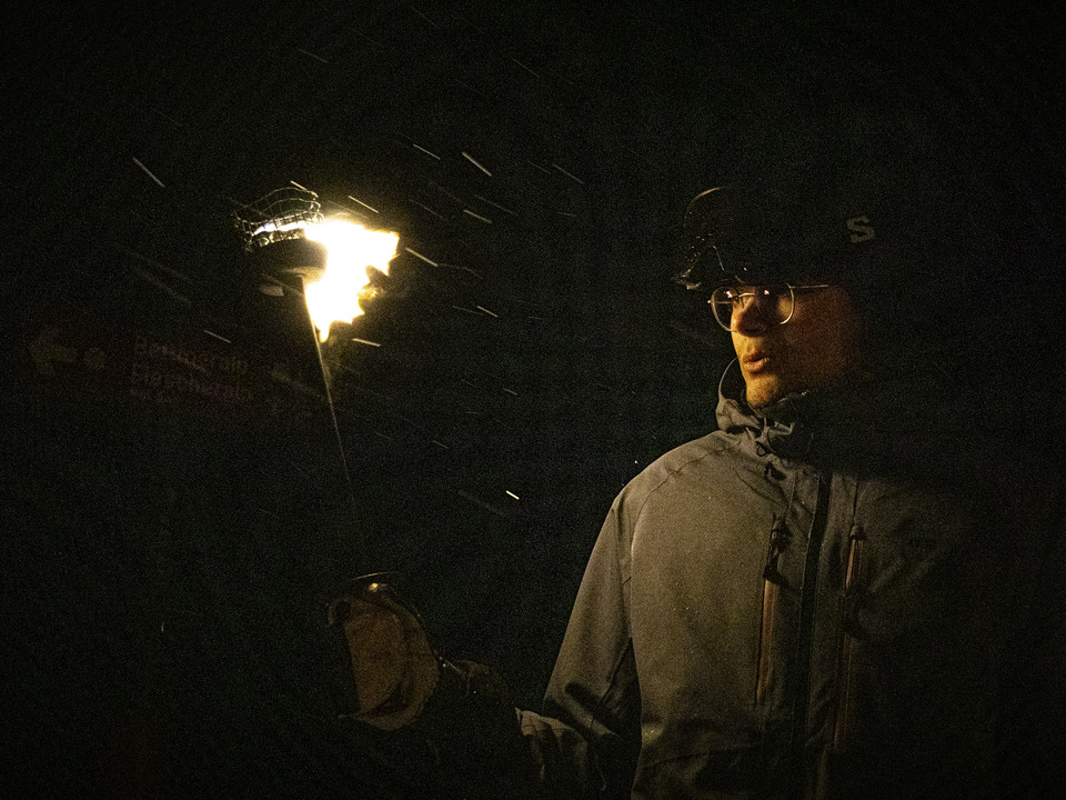 Skieur avec torche la nuit Teilnehmer hält eine Fackel in der Hand während des Mondscheinessen Aletsch Arena auf dem BettmerhornParticipant holding a torch during the Aletsch Arena moonlight dinner on the BettmerhornUn participant tient une torche à la main pendant le dîner au clair de lune de l'Aletsch Arena au Bettmerhorn.