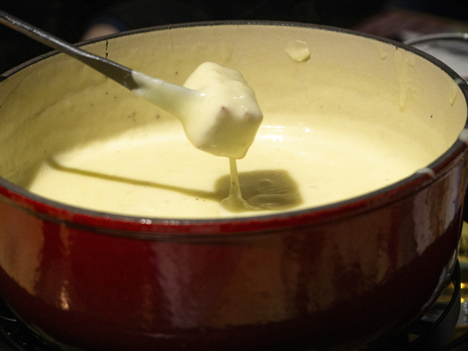 Traditionelles Käsefondue am Bettmerhorn Käsefondue im Topf serviert beim Mondscheinessen Aletsch Arena auf dem Bettmerhorn im WinterCheese fondue served in a pot at the Aletsch Arena moonlight dinner on the Bettmerhorn in winterFondue au fromage servie dans une marmite lors du dîner au clair de lune Aletsch Arena sur le Bettmerhorn en hiver