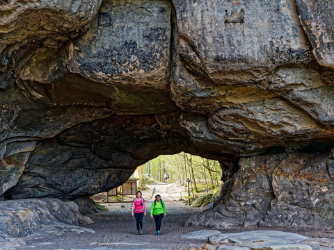 Großes Felsentor mit zwei WanderinnenLarge rock gate with two female hikersVelká skalní brána se dvěma turistkamiDuża skalna brama z dwiema turystkamiGroot rotshek met twee vrouwelijke wandelaarsGrande cancello di roccia con due escursioniste