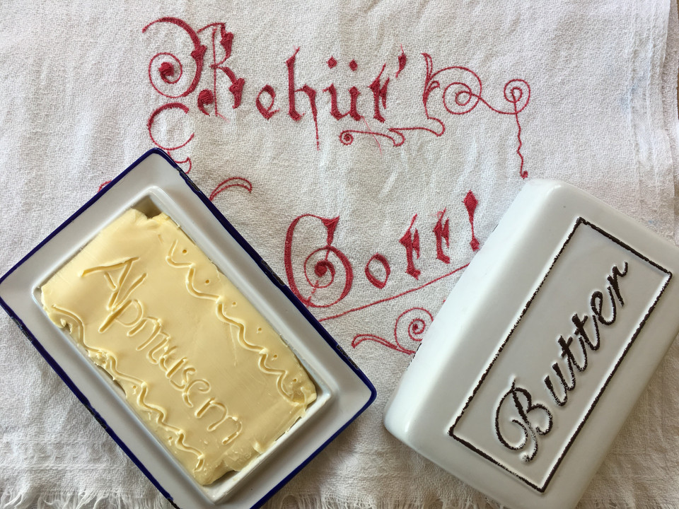 Butter with embossing in the Riederalp Alpine Museum Schaubuttern Alpmuseum Aletsch mit frisch geformter Butter in traditioneller Holzform auf besticktem LeinentuchAletsch Alpine Museum show churn with freshly churned butter in a traditional wooden mold on embroidered linen clothHuîtres de présentation du musée d'alpage d'Aletsch avec du beurre fraîchement moulé dans un moule en bois traditionnel sur une toile de lin brodée