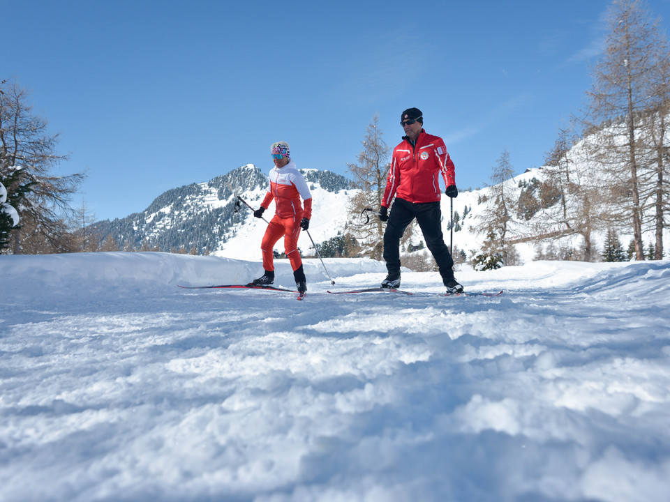 Apprendre le ski de fond avec un entraîneur à Riederalp Langlauf Schnupperkurs Riederalp mit Langlauftrainer und Teilnehmer auf der Loipe im sonnigen WinterpanoramaCross-country taster course Riederalp with cross-country trainer and participants on the trail in the sunny winter panoramaCours d'initiation au ski de fond à Riederalp avec entraîneur de ski de fond et participants sur la piste dans un panorama hivernal ensoleillé