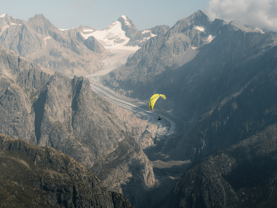Paragliding over the Fiescher Glacier Aletsch Fly Deluxe Paragliding mit gelbem Schirm über dem Fieschergletscher in der Aletsch ArenaAletsch Fly Deluxe paragliding with a yellow glider over the Fiescher Glacier in the Aletsch ArenaAletsch Fly Deluxe Parapente avec aile jaune au-dessus du glacier de Fiesch dans l'Aletsch Arena