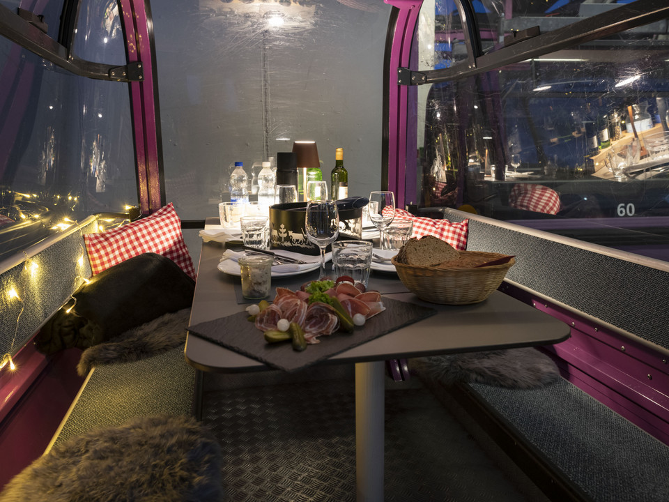 Alpine cuisine in the gondola Fonduegondel Bettmerhorn mit gedecktem Tisch, Walliser Spezialitäten und Wein für ein unvergessliches Abendessen im WinterBettmerhorn fondue gondola with table setting, Valais specialties and wine for an unforgettable dinner in winterTélécabine à fondue Bettmerhorn avec table dressée, spécialités valaisannes et vin pour un dîner inoubliable en hiver
