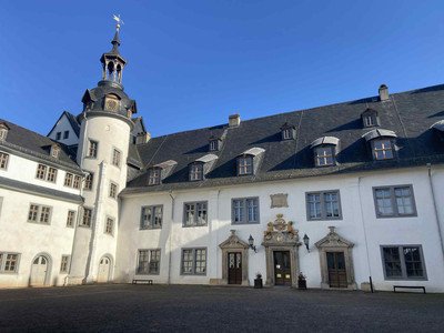 Schlosshof Stolberg Historisches Schlossgebäude in Stolberg mit Turm, großen Fenstern und blauem Himmel im Hintergrund.