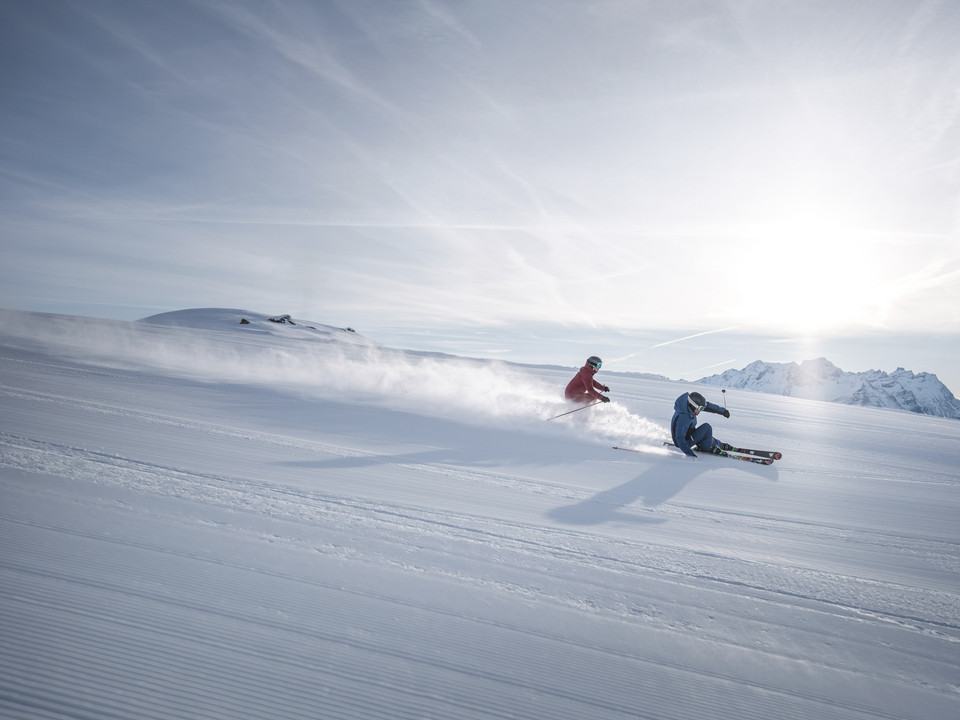Des virages parfaits sur des pistes fraîches Skipass Aletsch Arena mit zwei Skifahrern beim sportlichen Carving auf perfekt präparierter Piste unter der WintersonneAletsch Arena ski pass with two skiers carving on perfectly groomed slopes under the winter sunForfait Aletsch Arena avec deux skieurs en train de faire du carving sportif sur une piste parfaitement préparée sous le soleil d'hiver
