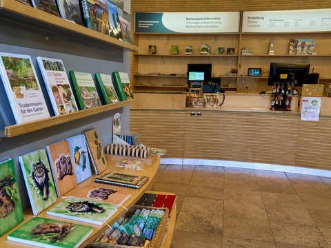 Nationalparkzentrum Eingangsbereich mit Souvenirshop Innenansicht des Nationalpark-Besucherzentrums mit Büchern und Souvenirs auf Regalen, Rezeption im Hintergrund.