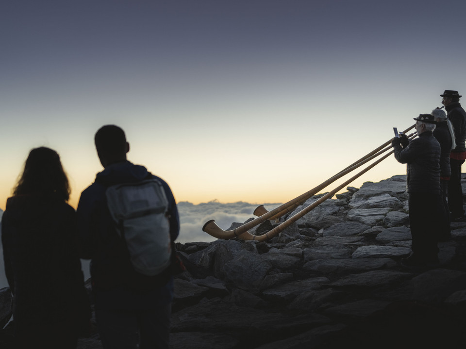 Joueurs de cor des Alpes à l'aube Sonnenaufgangsfahrt Eggishorn mit Alphornbläsern beim Spiel im Morgenlicht vor der AlpenkulisseEggishorn sunrise ride with alphorn players playing in the morning light against the Alpine backdropVoyage au lever du soleil Eggishorn avec des joueurs de cor des Alpes jouant dans la lumière du matin devant le décor alpin