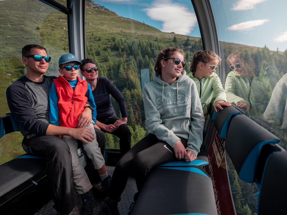 Prendre de la hauteur en famille Einzelfahrten Aletsch Arena mit Familie in der Gondelbahn auf dem Weg zu den Bergen der Aletsch Arena im SommerSingle rides Aletsch Arena with family in the gondola lift on the way to the mountains of the Aletsch Arena in summerCourses individuelles Aletsch Arena en famille en télécabine sur le chemin des montagnes de l'Aletsch Arena en été